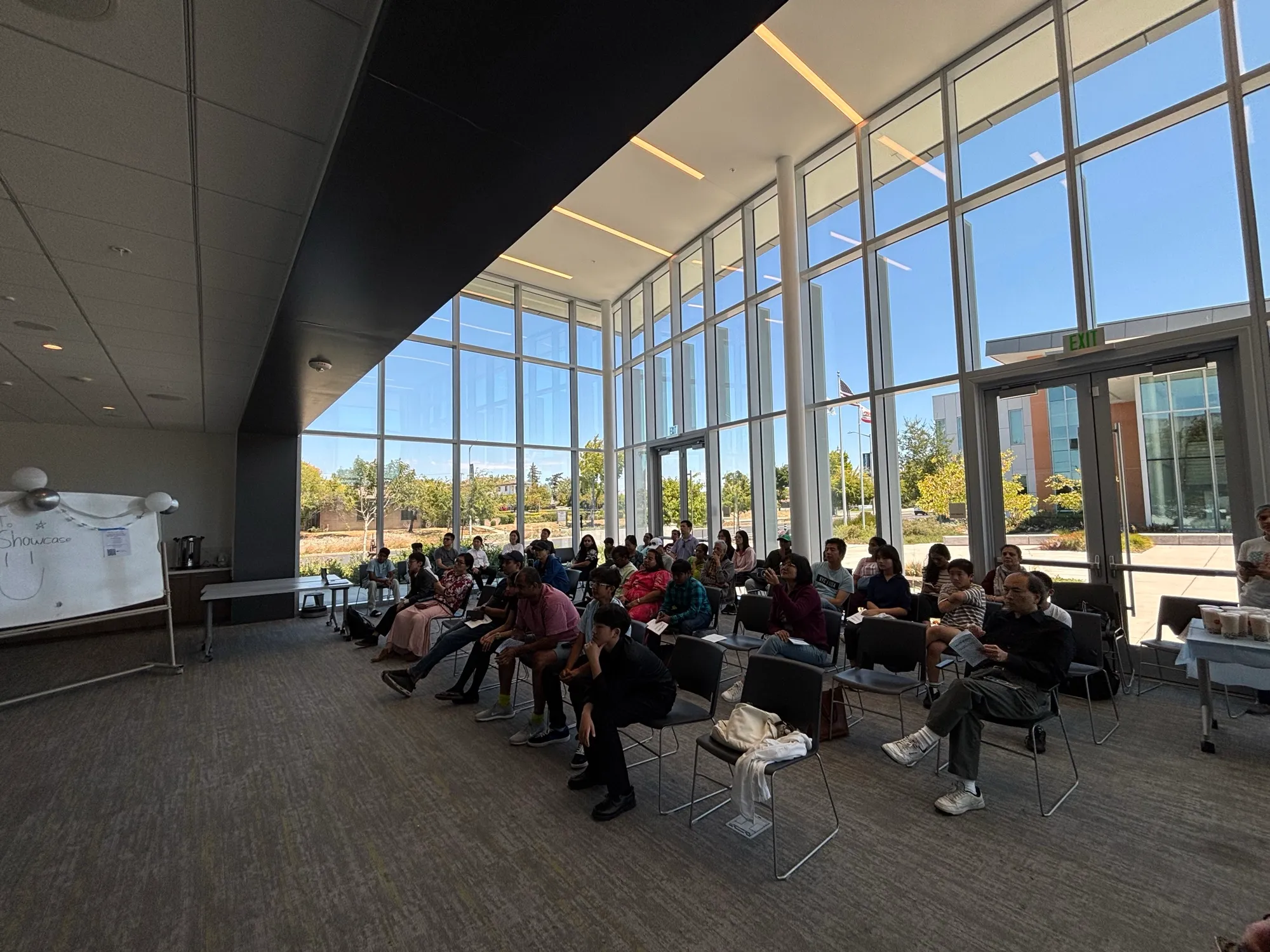 Families seated in the Community Room's glass atrium, sunlight streaming in.